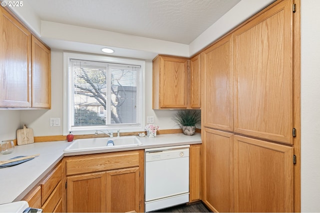 kitchen featuring white dishwasher, sink, a textured ceiling, and light brown cabinets