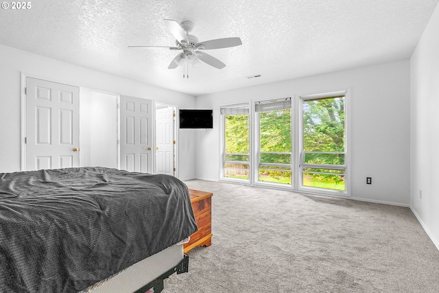 carpeted bedroom with baseboards, a ceiling fan, and a textured ceiling