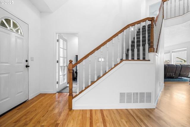 entrance foyer featuring stairway, wood finished floors, and a healthy amount of sunlight