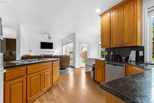 kitchen featuring light wood-style floors, white gas cooktop, brown cabinets, and dishwasher