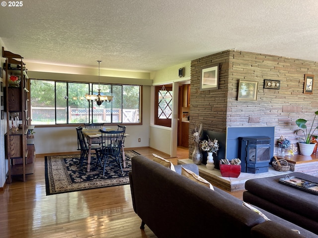 54824 Robinson Rd, Coquille, OR 97423 - living room featuring a textured ceiling, baseboards, hardwood / wood-style floors, and a chandelier
