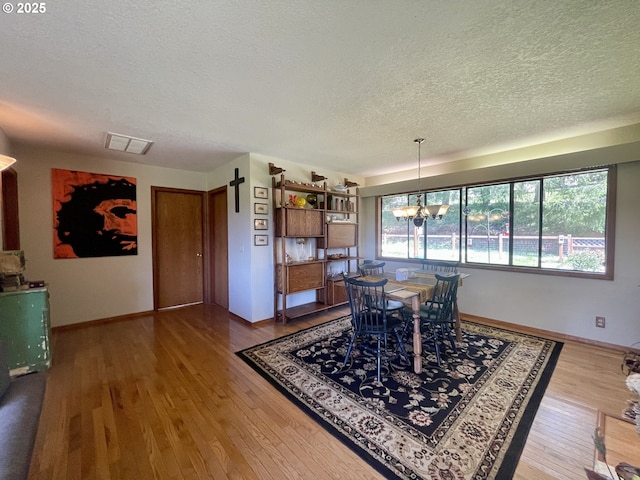 54824 Robinson Rd, Coquille, OR 97423 - dining area featuring a textured ceiling, a chandelier, wood finished floors, and baseboards