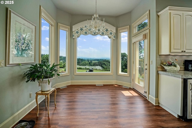 7947 Lavender Ln, Turner, OR 97392 - unfurnished dining area with dark wood-type flooring, a chandelier, baseboards, and wine cooler