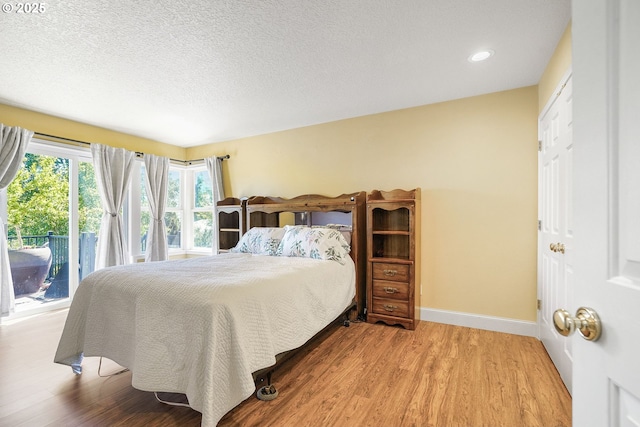 80 Sweden Cir, Silverton, OR 97381 - bedroom with wood finished floors, recessed lighting, a textured ceiling, and access to exterior