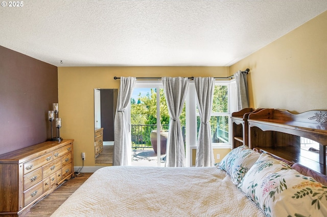 80 Sweden Cir, Silverton, OR 97381 - bedroom with wood finished floors, access to exterior, and a textured ceiling
