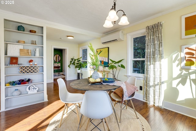 dining space featuring built in shelves, crown molding, a wall mounted air conditioner, a chandelier, and hardwood / wood-style flooring