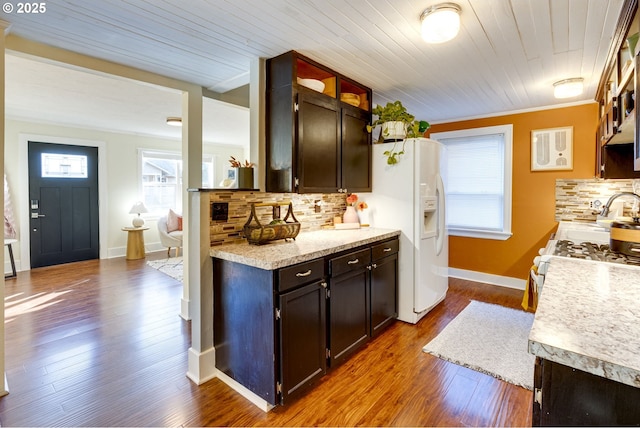 kitchen with wood-type flooring, decorative backsplash, dark brown cabinets, and a healthy amount of sunlight