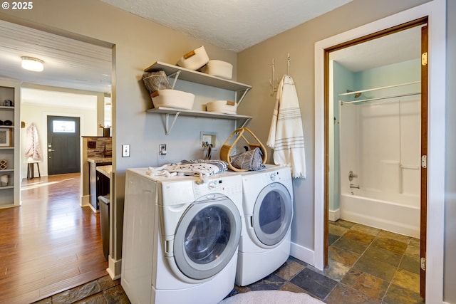 washroom with a textured ceiling and washer and clothes dryer