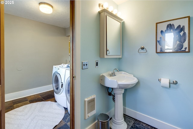 bathroom featuring sink, a textured ceiling, and washer and clothes dryer