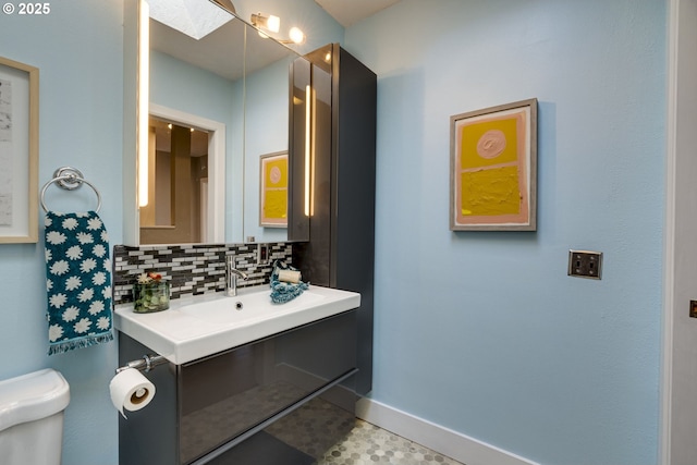 bathroom with tasteful backsplash, vanity, and toilet