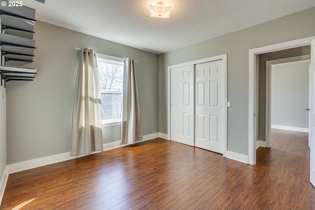 unfurnished bedroom featuring a closet and dark hardwood / wood-style floors