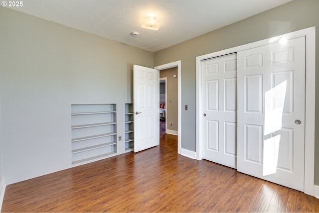 unfurnished bedroom featuring dark wood-type flooring and a closet