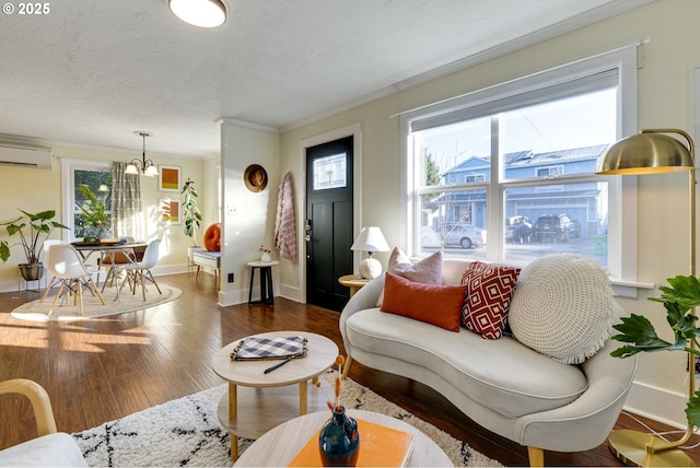 living room featuring a wall mounted air conditioner, ornamental molding, a notable chandelier, dark wood-type flooring, and a textured ceiling