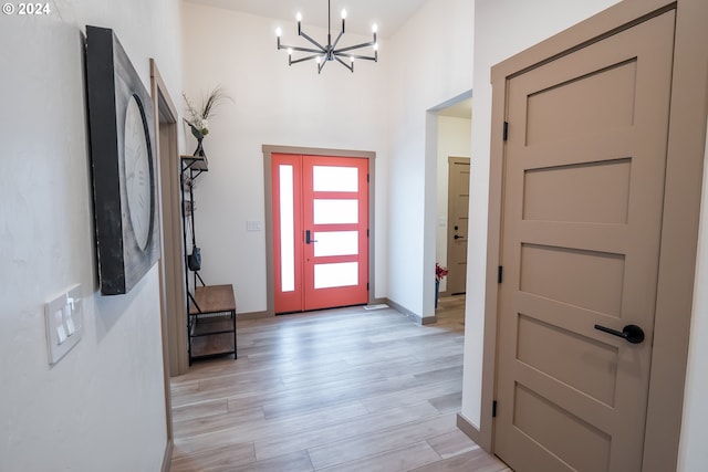 foyer with light hardwood / wood-style flooring and an inviting chandelier