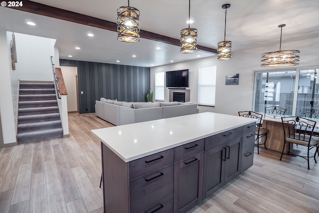 kitchen featuring decorative light fixtures, a center island, and light hardwood / wood-style flooring