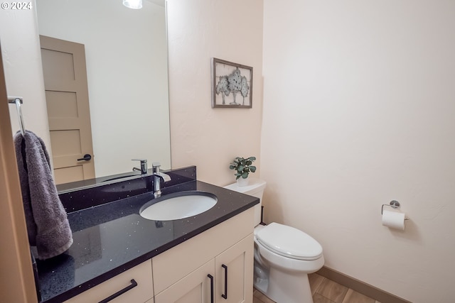 bathroom with hardwood / wood-style floors, toilet, and vanity