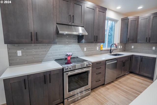 kitchen featuring dark brown cabinets, stainless steel appliances, light hardwood / wood-style floors, and backsplash