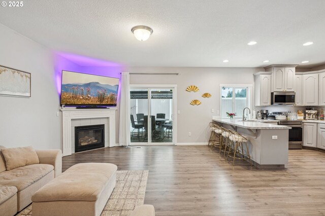 12711 NE 49th Way, Vancouver, WA 98682 - living room with wood finished floors, a tiled fireplace, and baseboards