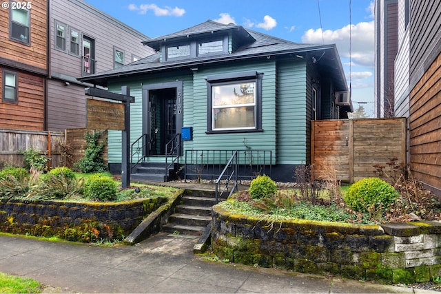 view of front of house with roof with shingles and fence