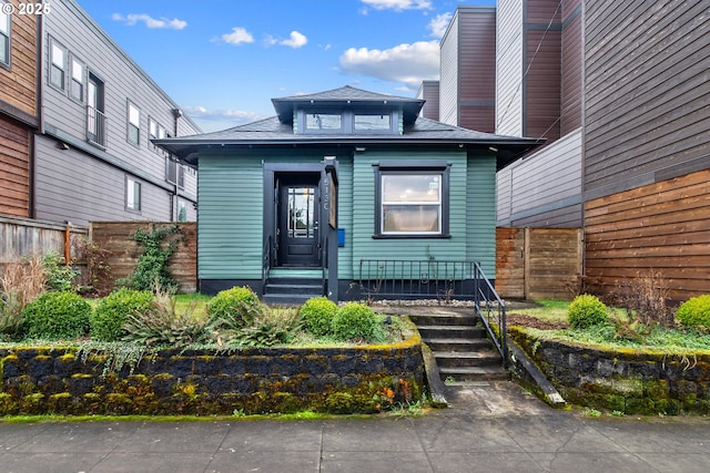 property entrance featuring a shingled roof and fence