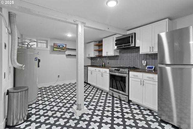 kitchen featuring dark countertops, open shelves, water heater, stainless steel appliances, and tile patterned floors