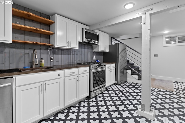 kitchen featuring a sink, stainless steel appliances, dark countertops, and tile patterned floors