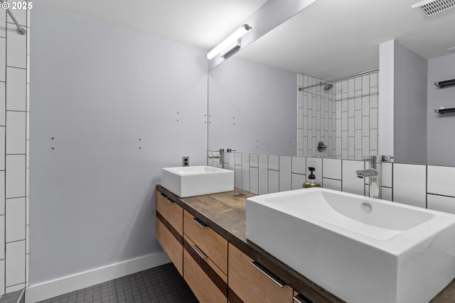 bathroom with tile patterned floors, visible vents, double vanity, a sink, and a shower