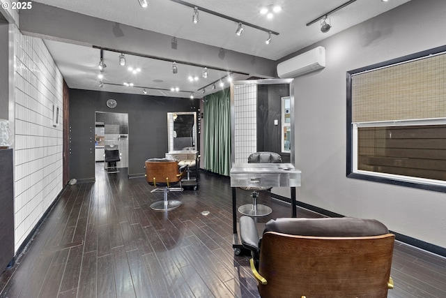 interior space with a wall unit AC, wood finished floors, and baseboards