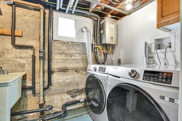 laundry room with a sink, washer and clothes dryer, cabinet space, and water heater