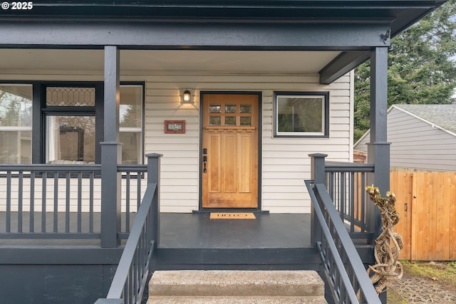 property entrance with fence and covered porch