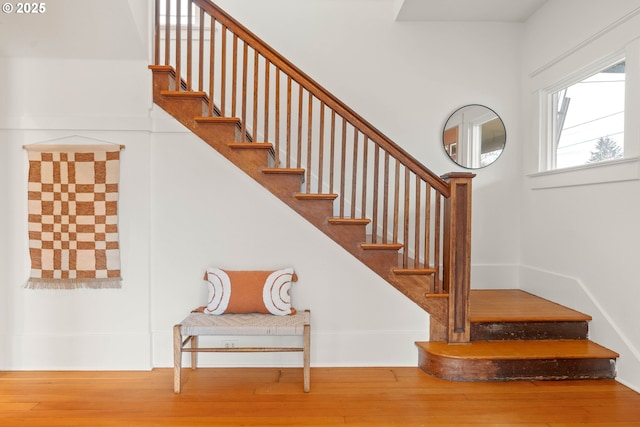 staircase with hardwood / wood-style floors and baseboards