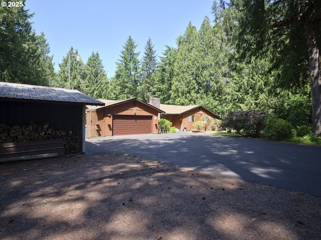 135 Ridgecrest Dr, Toledo, WA 98591 - view of front of home with driveway, an attached garage, and a chimney
