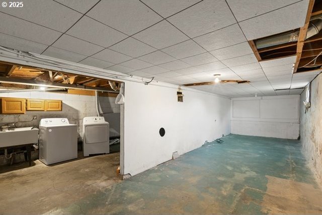 unfinished below grade area featuring independent washer and dryer and a sink