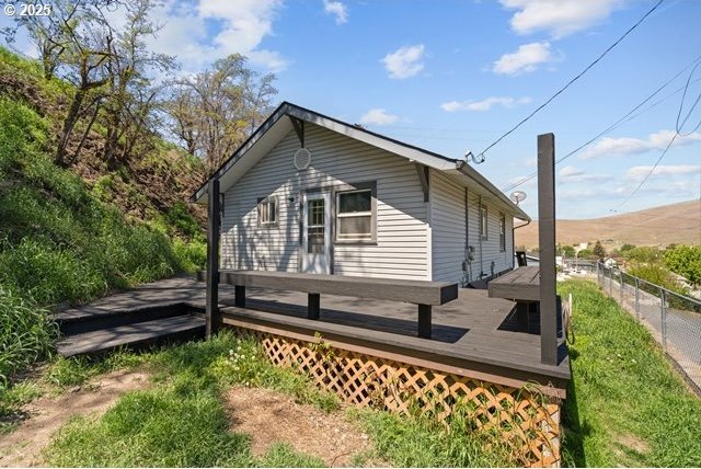 view of side of home featuring fence and a deck