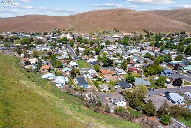 aerial view of property's location with a mountain backdrop and nearby suburban area