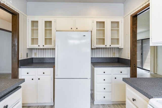224 N Hayden Bay Dr, Portland, OR 97217 - kitchen featuring freestanding refrigerator, dark countertops, and glass insert cabinets