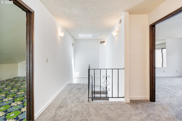 224 N Hayden Bay Dr, Portland, OR 97217 - hallway with carpet floors, an upstairs landing, a textured ceiling, and a skylight
