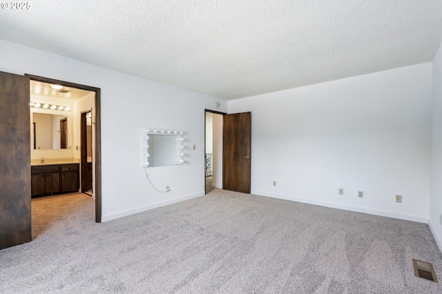 224 N Hayden Bay Dr, Portland, OR 97217 - unfurnished bedroom with light colored carpet, a textured ceiling, and connected bathroom
