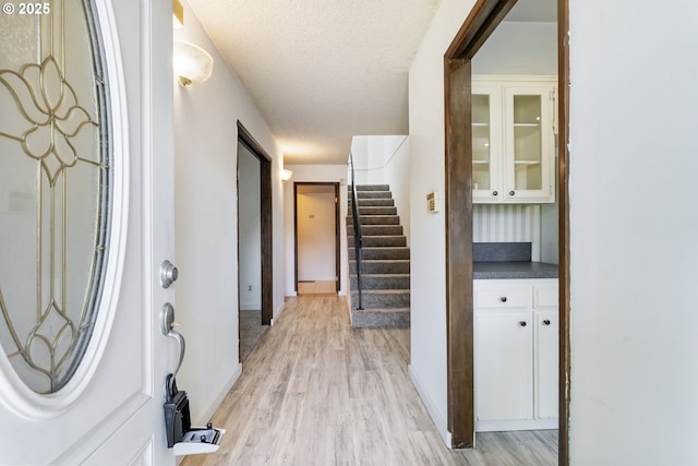 224 N Hayden Bay Dr, Portland, OR 97217 - entryway with light wood-type flooring, stairs, and a textured ceiling