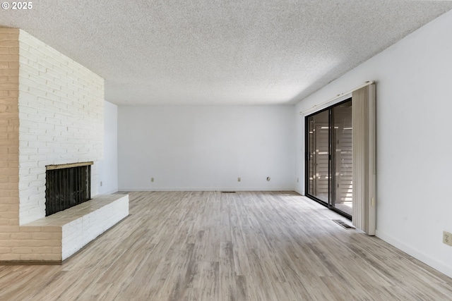224 N Hayden Bay Dr, Portland, OR 97217 - unfurnished living room with wood finished floors, a textured ceiling, and a fireplace