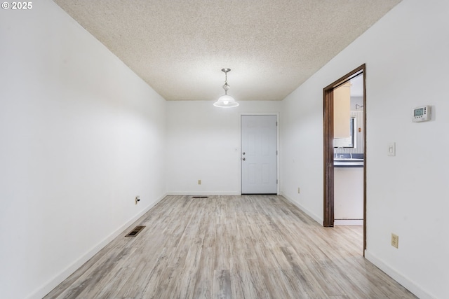 224 N Hayden Bay Dr, Portland, OR 97217 - unfurnished dining area with light wood finished floors and a textured ceiling
