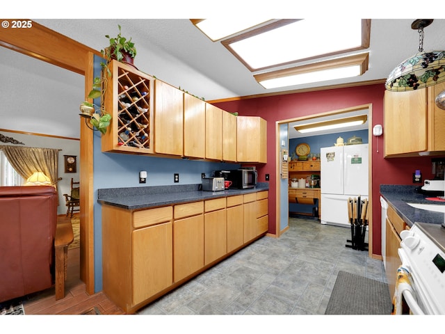 kitchen with freestanding refrigerator, stainless steel microwave, range, and dark countertops