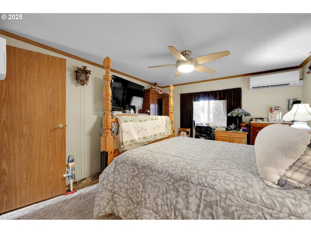 bedroom featuring a ceiling fan, a textured ceiling, a wall unit AC, and ornamental molding