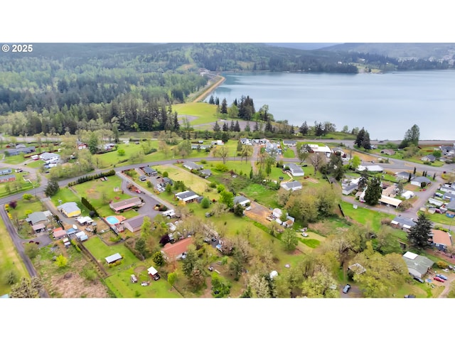drone / aerial view featuring a water view, a residential view, and a wooded view