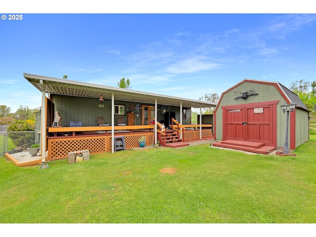back of house with an outdoor structure, fence, a wooden deck, a lawn, and a storage shed