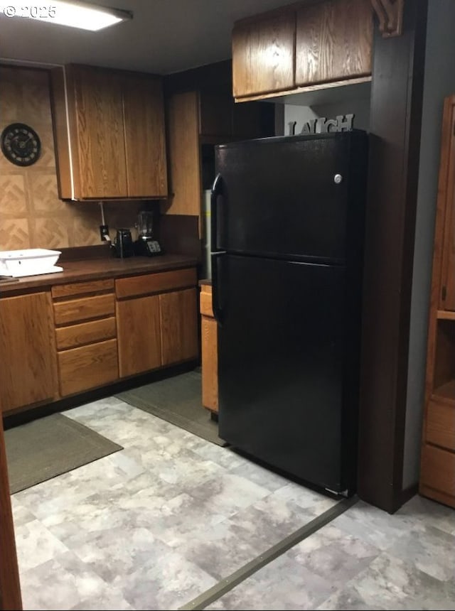 39028 Dexter Rd, Dexter, OR 97431 - kitchen with freestanding refrigerator, light floors, brown cabinets, and dark countertops