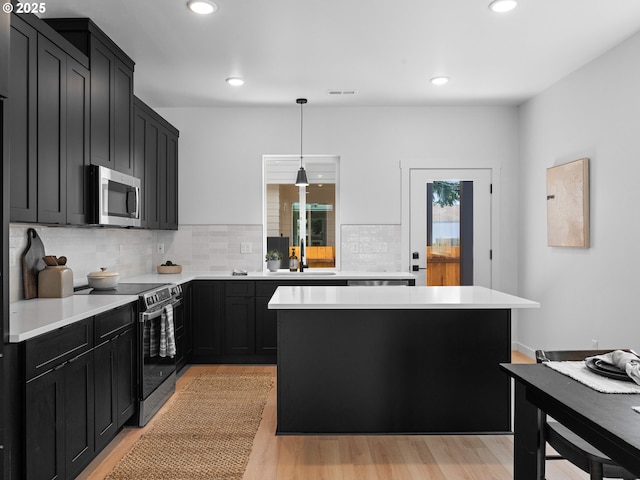 7195 SE Crystal Springs Blvd Unit 7, Portland, OR 97206 - kitchen with stainless steel appliances, dark cabinetry, light countertops, and recessed lighting