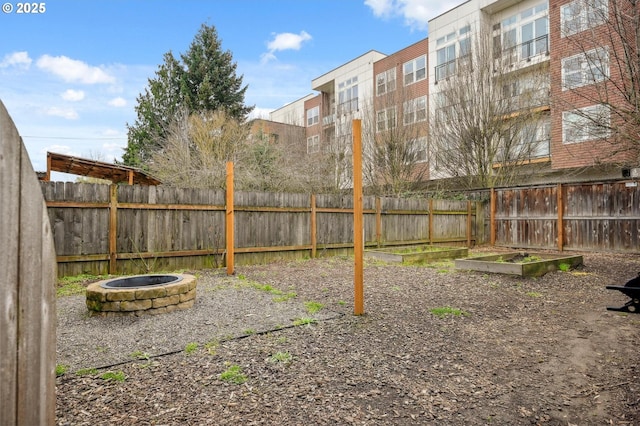 view of yard featuring fence and an outdoor fire pit