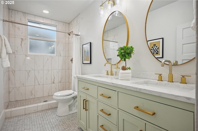 bathroom featuring a sink, double vanity, toilet, and tiled shower