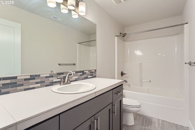 full bath with tasteful backsplash, visible vents, toilet, tub / shower combination, and vanity